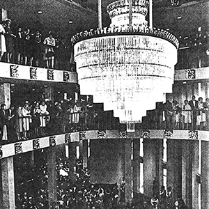 1960s Civic Theater interior with guests filling all balcony levels that circle the chandelier.