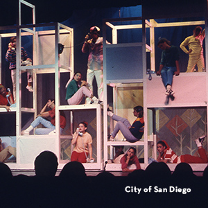 1960s musical cast performing on a multi-level scaffold set on the Civic Theatre stage.